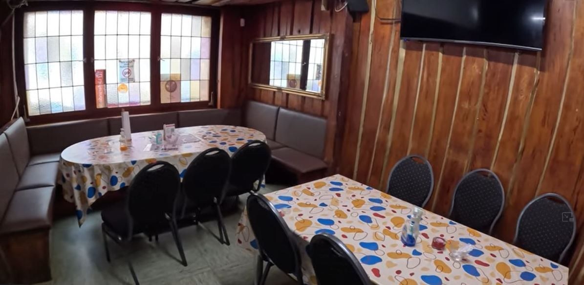 The Afrolink dining room with wood-panelled walls and set tables