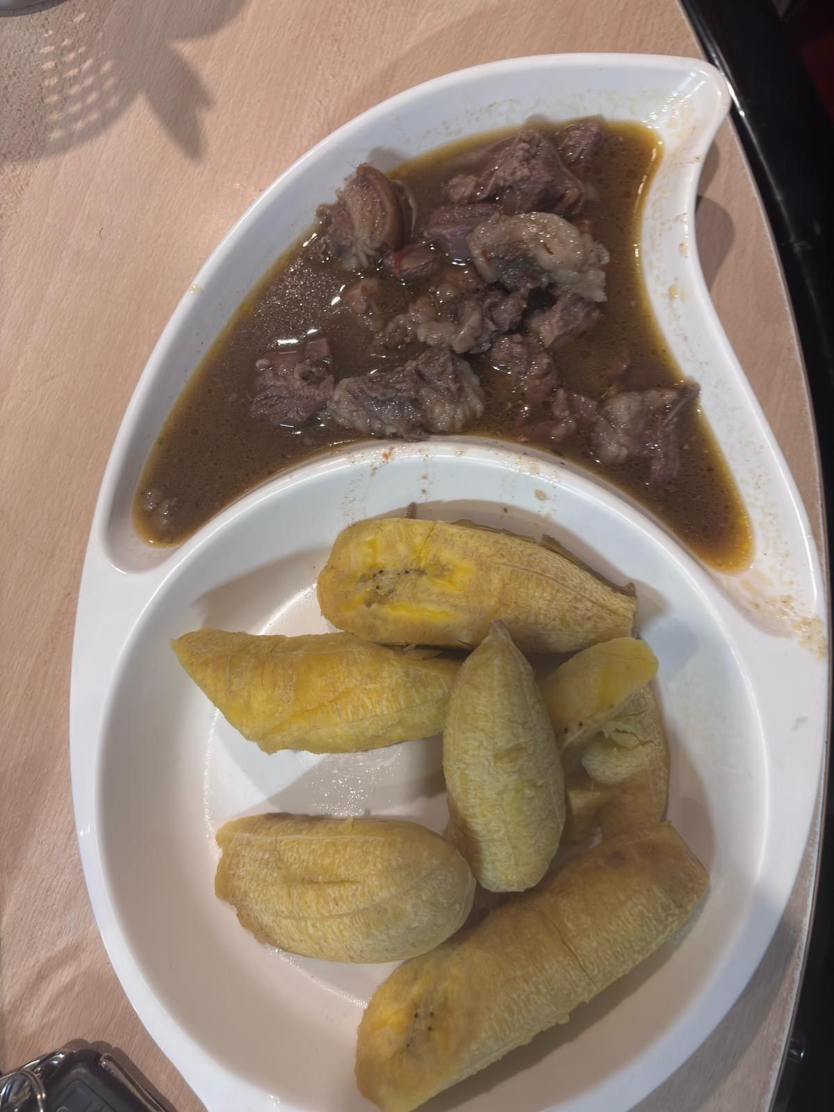 Boiled plantain with meat in sauce in a divided dish