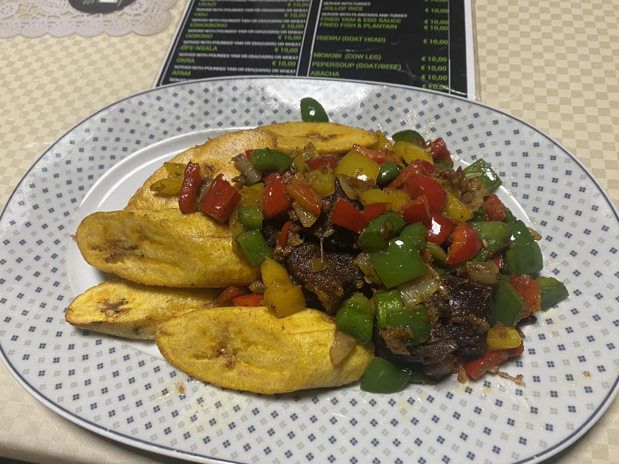 Fried plantain topped with peppered meat and bell peppers