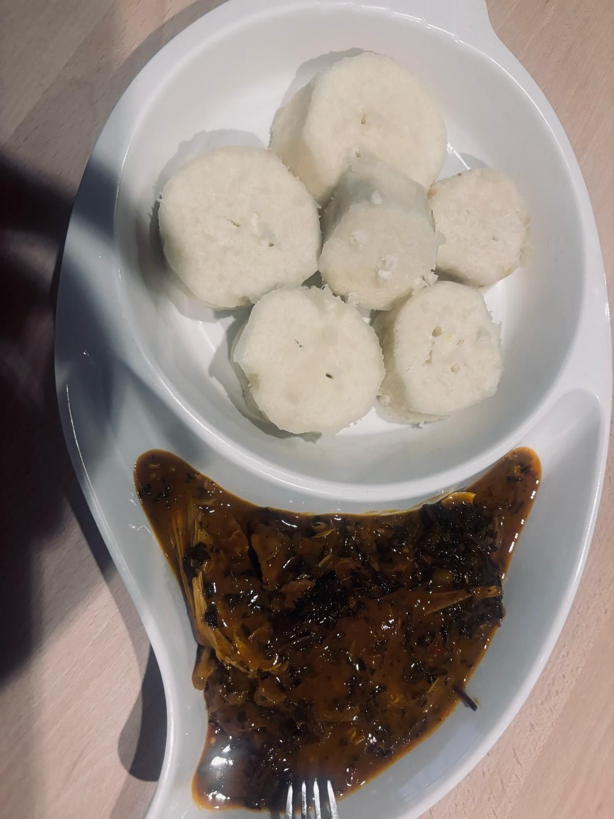 Pounded yam portions in a divided dish with a dark soup