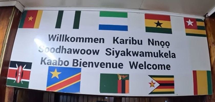 Sign in the dining room with flags of African nations and the word welcome in several languages