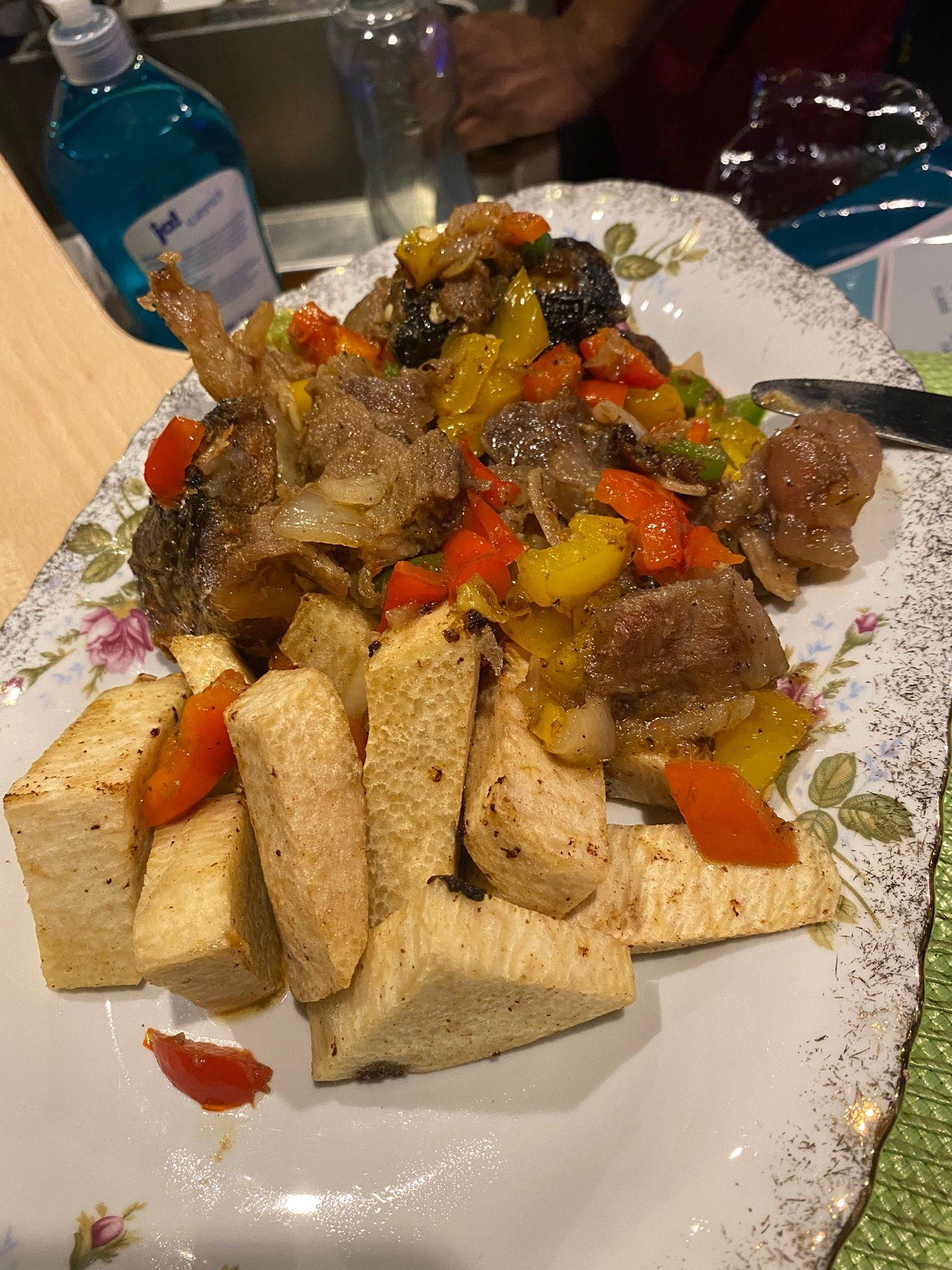 Yam with peppered meat, carrots and onions on a floral plate